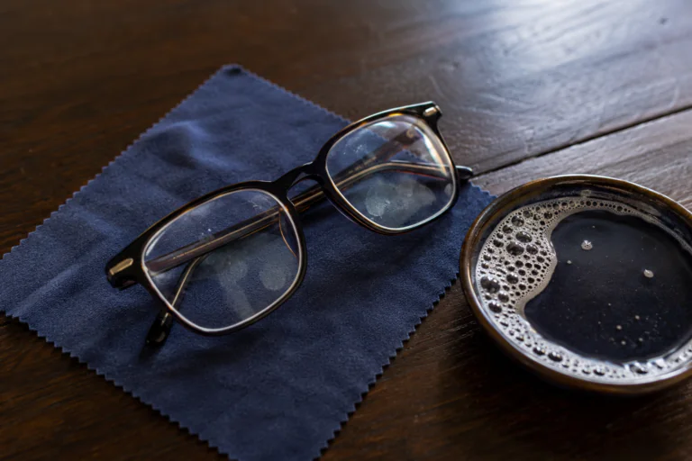 Lunettes avec traces de doigts posées sur une microfibre avant un nettoyage doux