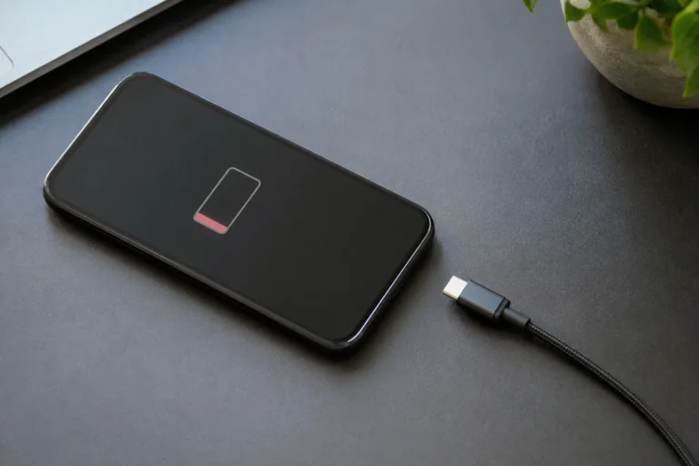 Smartphone générique posé sur un bureau avec câble de charge débranché
