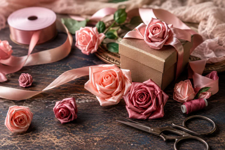 Roses décoratives en ruban satin avec matériel créatif sur une table d'atelier